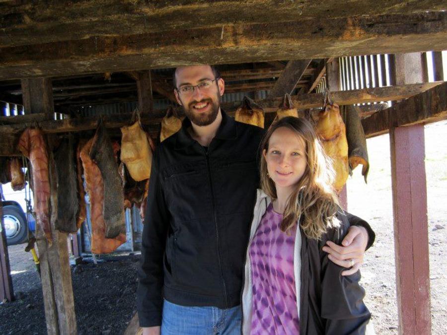 me and my wife standing under a shed with shark being hung to ferment