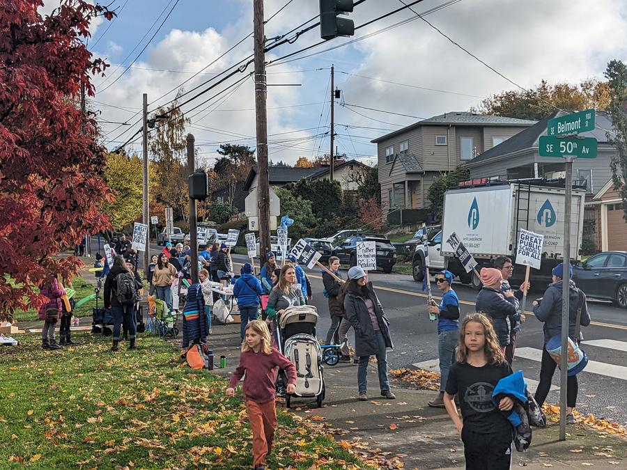Teachers and families picketing in front of a school